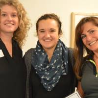 Two alumnae and a student pose for a photo at the Academic Major Fair.